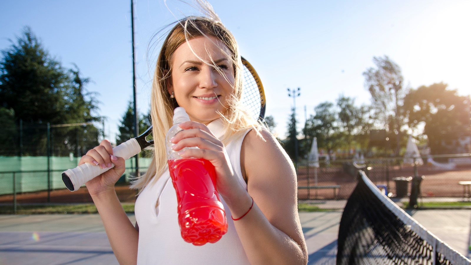 Female tennis player drinking an electrolyte beverage